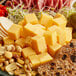 A plate of cubed Tillamook Sharp Yellow Cheddar Cheese with nuts.