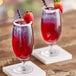 Two glasses of Tiki Breeze pink drink with strawberries on top.