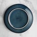An Acopa Highlands blue coupe china plate with a white rim.