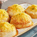 Shredded Tillamook sharp yellow cheddar cheese on a plate of food.