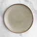 An Acopa Highlands heather gray coupe china plate on a marble surface.