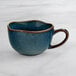 An Acopa Highlands blue and brown ceramic cup.