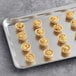 A baking tray with Cuisine Innovations Mini Lorraine Quiches on a gray surface.