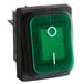 A green push button switch with a white circle.