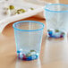 A pair of Solo cobalt blue plastic cups with pills inside.