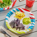 A table set with Solo Tropics paper plates and utensils.