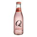 A close-up of a Q Mixers Sparkling Grapefruit bottle filled with pink liquid.