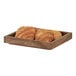 A Cal-Mil wooden display box with croissants on a table.