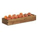 A Cal-Mil walnut display box filled with peaches and oranges on a table.