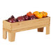 A Cal-Mil oak display stand with a wooden crate full of vegetables.