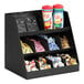 A black Cal-Mil 3-tier condiment organizer on a counter with condiments.