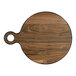 A round walnut serving board with a handle.