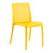 A yellow resin side chair with holes in the back.