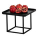 A black square metal display riser with pomegranates on it.