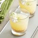 Two glasses of Les Vergers Boiron lime puree drinks with whipped cream and lime garnish.