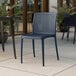 A blue resin side chair with a perforated backrest and seat, designed for outdoor use.