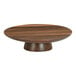 A Cal-Mil Sydney round walnut cake stand on a wooden table.