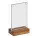 A clear acrylic sign on a wood base with a walnut finish.