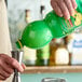 A hand pouring ReaLemon lemon juice into a metal cup.