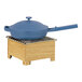 A blue pan with a lid on a wooden stand.