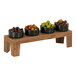 A group of bowls of olives on a Cal-Mil walnut display stand.