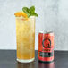 A can of Q Mixers Sparkling Grapefruit next to a glass of sparkling grapefruit juice with ice.