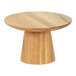 A round oak cake stand on a wooden table.