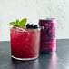 A glass of Q Mixers Hibiscus Ginger Beer with a fruit garnish on the rim.