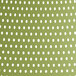 A white and green polka dot patterned tablecloth on an outdoor restaurant chair.