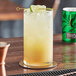 A glass of Q Mixers Premium Ginger Ale with a lime slice on a coaster.