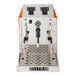 An automatic two-wand milk and beverage steamer with a stainless steel finish and orange side panels.