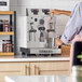 An Astra STA2400-WH gloss white automatic milk and beverage steamer with two wands on a countertop.