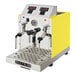 An automatic two-wand milk and beverage steamer with a gloss yellow exterior and stainless steel front panel.
