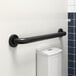 A white wall with a black Lavex grab bar.