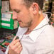 A man wearing a white shirt uses a Midland transparent surveillance headset.