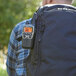 A person with a Midland X-TALKER walkie talkie on his backpack.