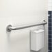 A Lavex restroom grab bar on a wall next to a toilet.
