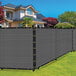 A gray SEALTECH privacy fence screen on a black fence in front of a house.
