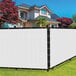 A white SEALTECH polyethylene mesh privacy fence screen on a fence in front of a house.
