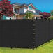 A black SEALTECH fabric privacy fence screen in front of a house.