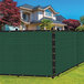 A green SEALTECH privacy fence screen in front of a house.