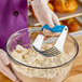 A person using an Ateco stainless steel pastry cutter to mix dough.