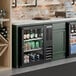 A black underbar height glass door back bar refrigerator filled with assorted beverages.