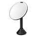 A round black stainless steel sensor mirror with a black base.
