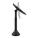 A simplehuman round black stainless steel mirror with a black stand.