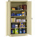 A Tennsco putty metal storage cabinet with many items on it.