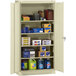 A Tennsco standard storage cabinet with solid doors filled with various items.