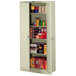 A Tennsco putty metal storage cabinet with shelves and boxes inside.