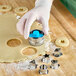A person using an Ateco Linzer Tart cookie cutter to cut out cookies.
