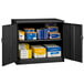 A black metal Tennsco storage cabinet with shelves full of boxes.